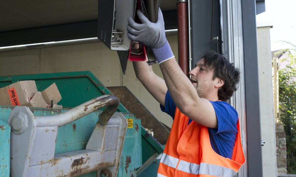 worker-at-a-waste-container-throwing-away-folders.jpg
